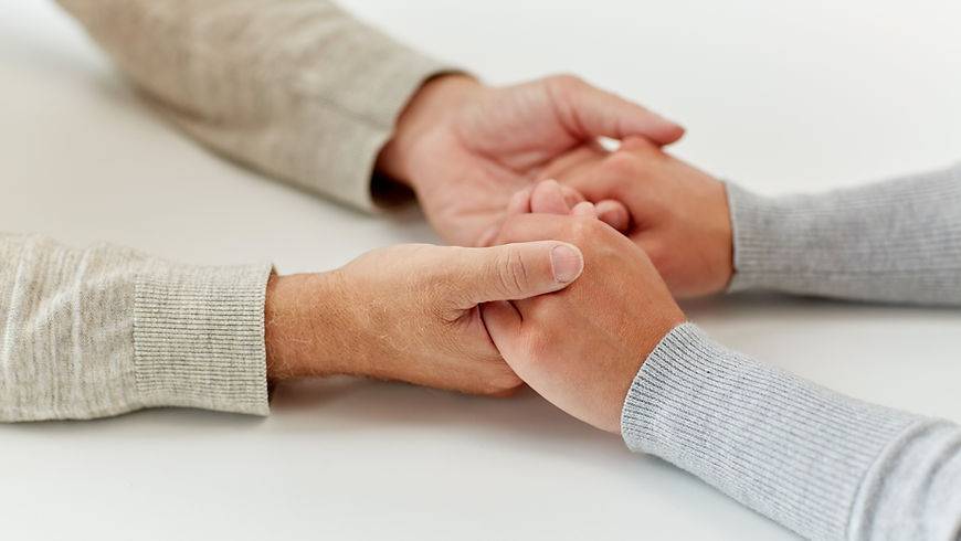 Two people holding hands in support