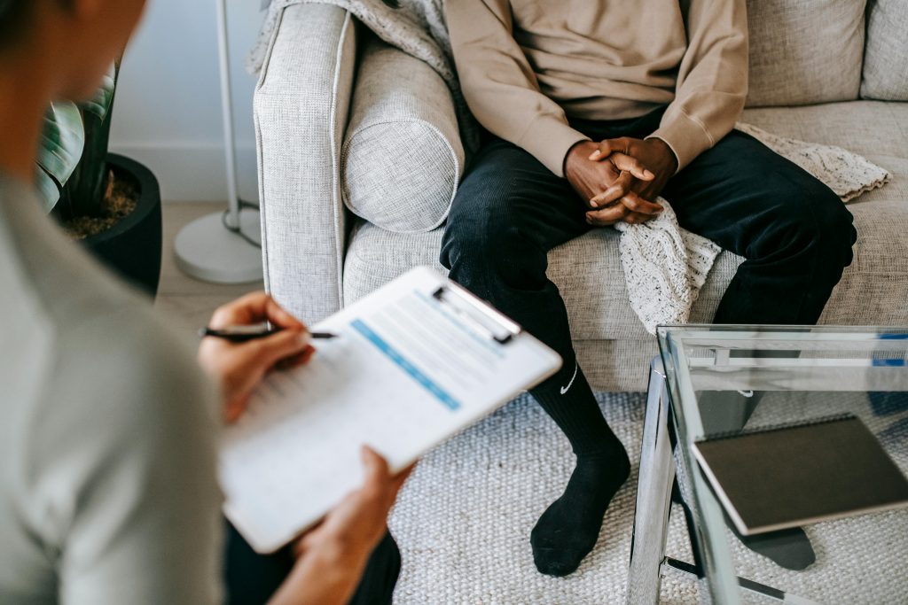 Clinician taking notes while talking with a patient